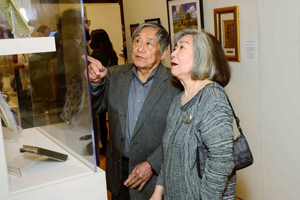 An elderly Asian American couple looks at an exhibit at “Our Vibrant AAPI Community."